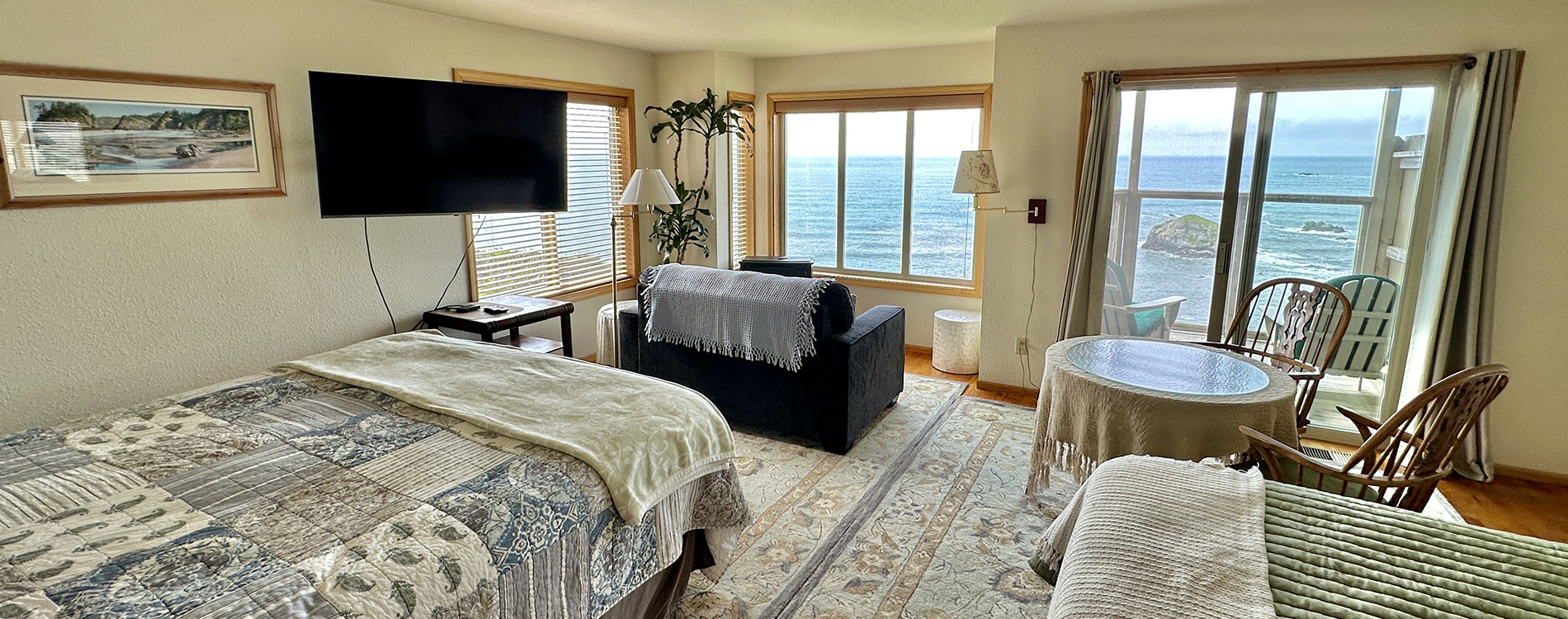 guest room with bed, couch, table and chairs plus a wonderful view of ocean
